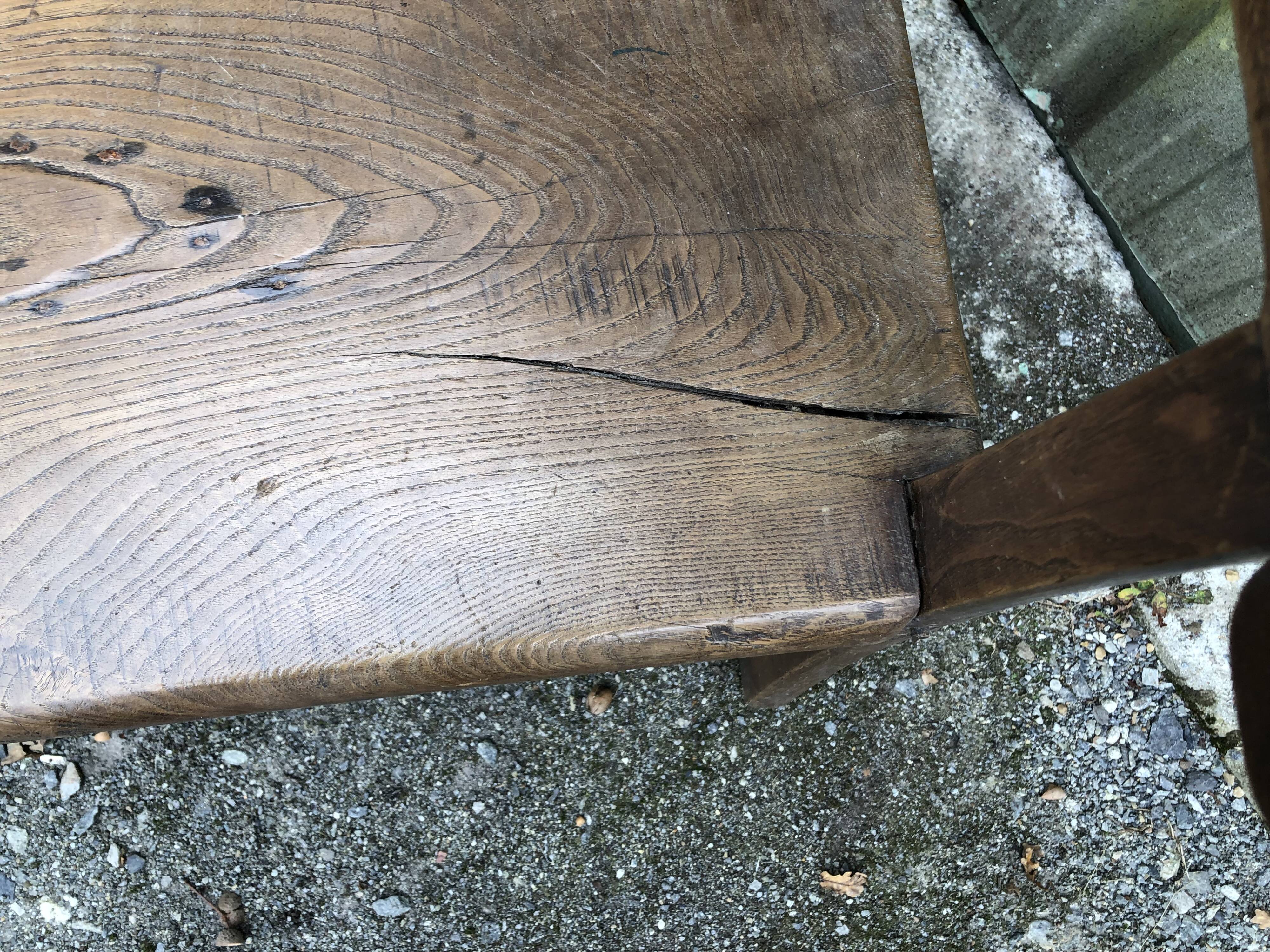 Duo of old solid oak benches with backs and armrests.