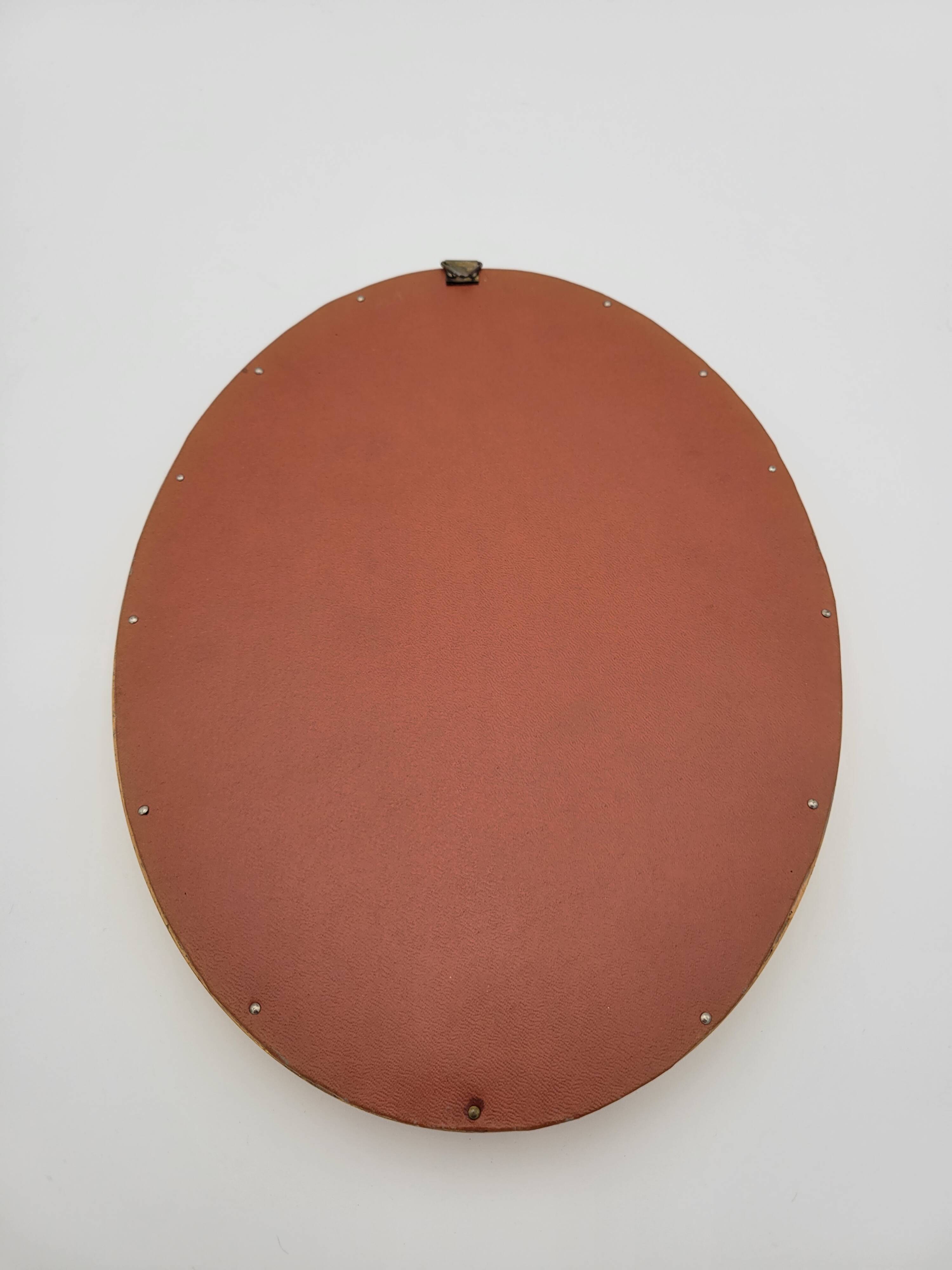 Small old oval mirror in gilded wood