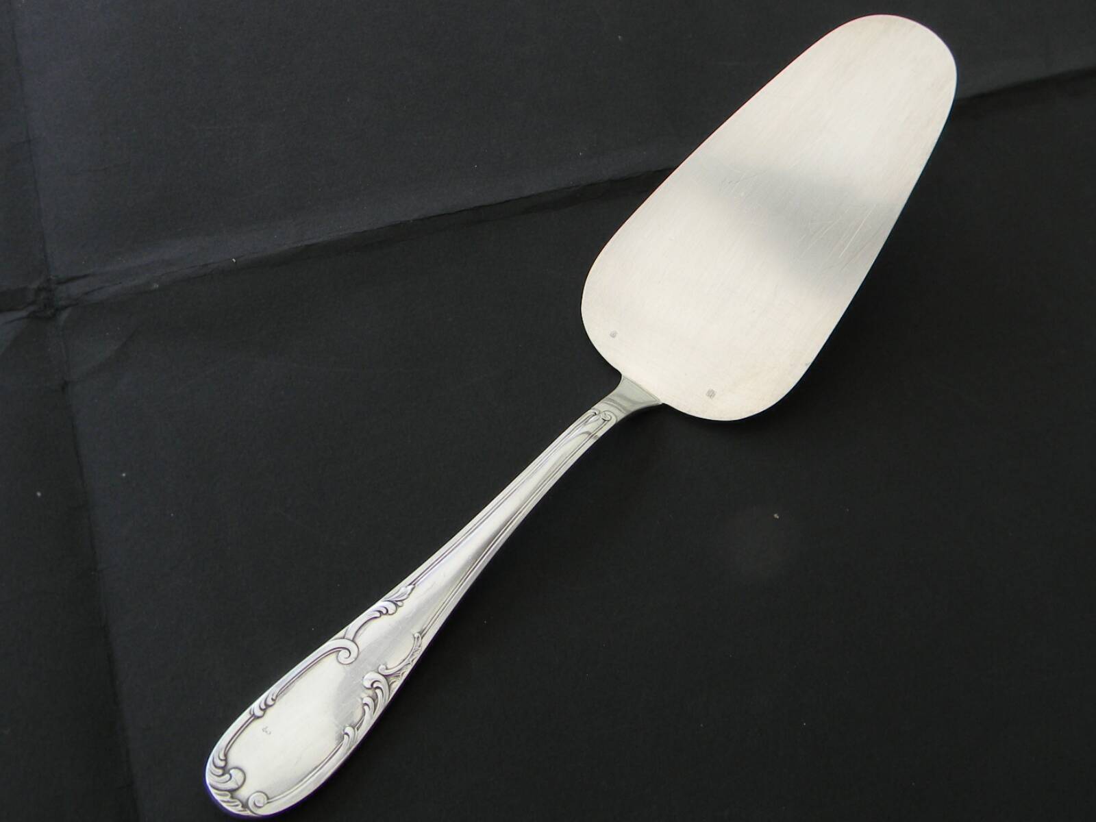 12 cake forks and a silver metal server.