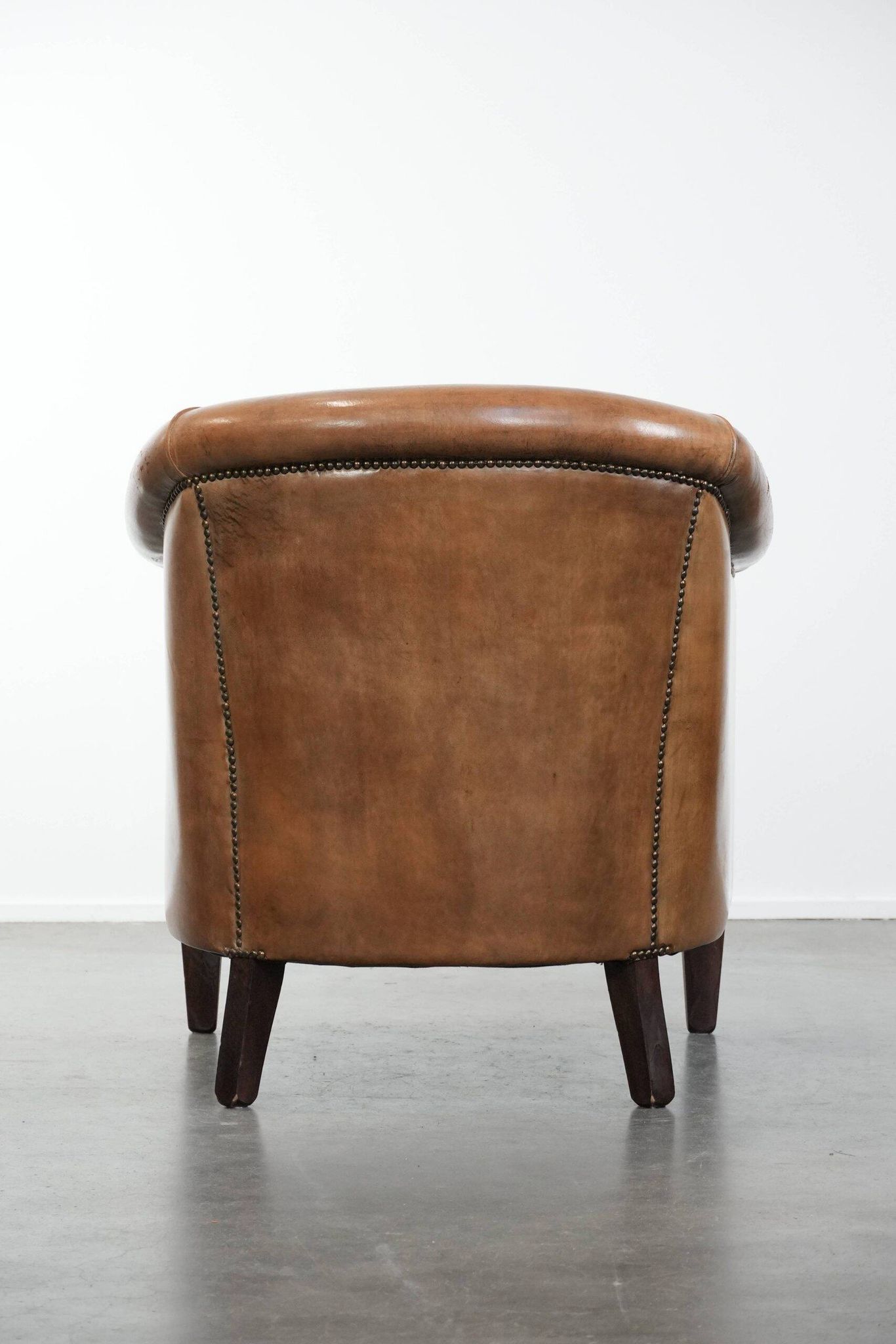 Characterful club chair made of sheepskin leather with light cognac colours