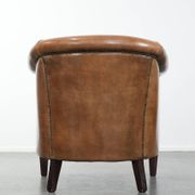 Characterful club chair made of sheepskin leather with light cognac colours