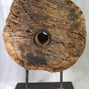 Old wooden pulley wheel on foot