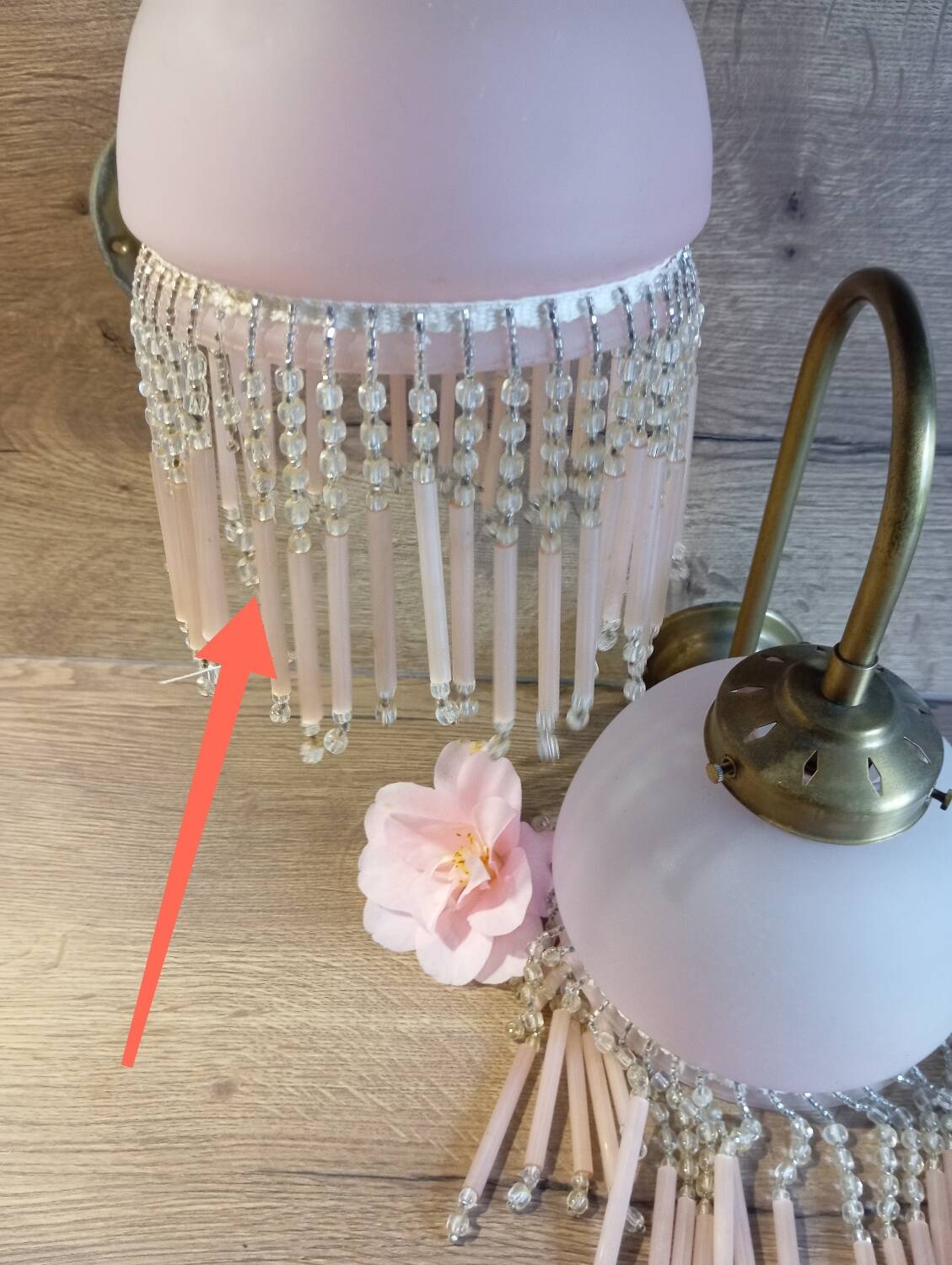 Brass swan neck wall lamp with pink glass globe and Charleston tassels