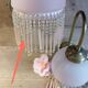 Brass swan neck wall lamp with pink glass globe and Charleston tassels
