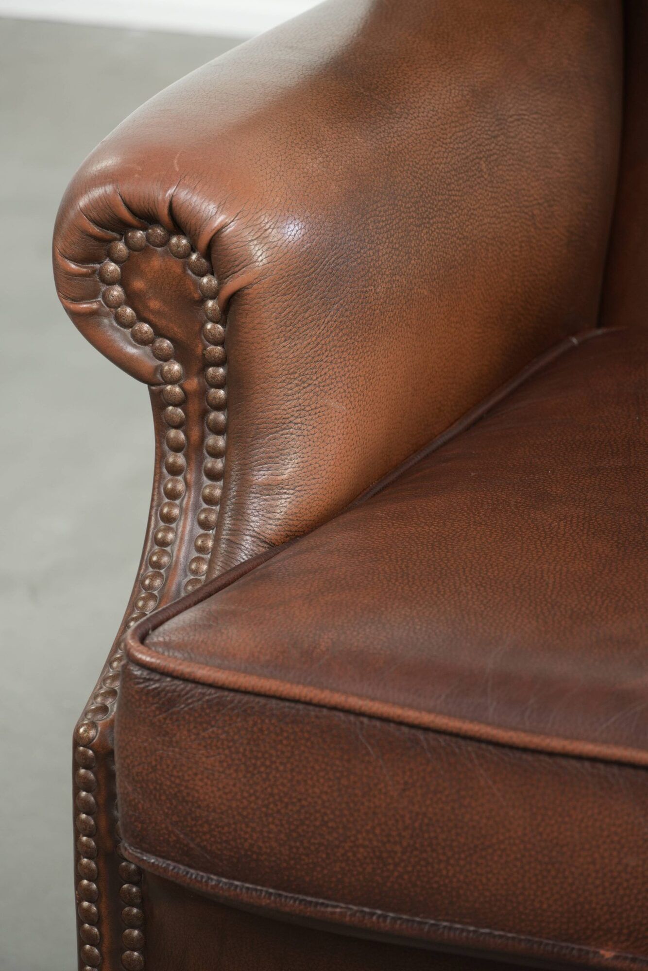 Cowhide wingback armchair in English style finished with decorative nails