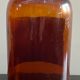Lot d'anciens flacons de parfumeurs en verre avec étiquettes d'origine