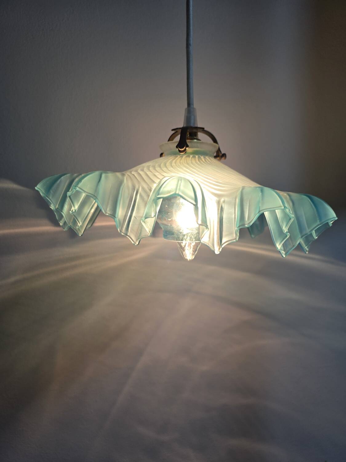 Suspension lampshade with scalloped edges in blue and its interior decoration.