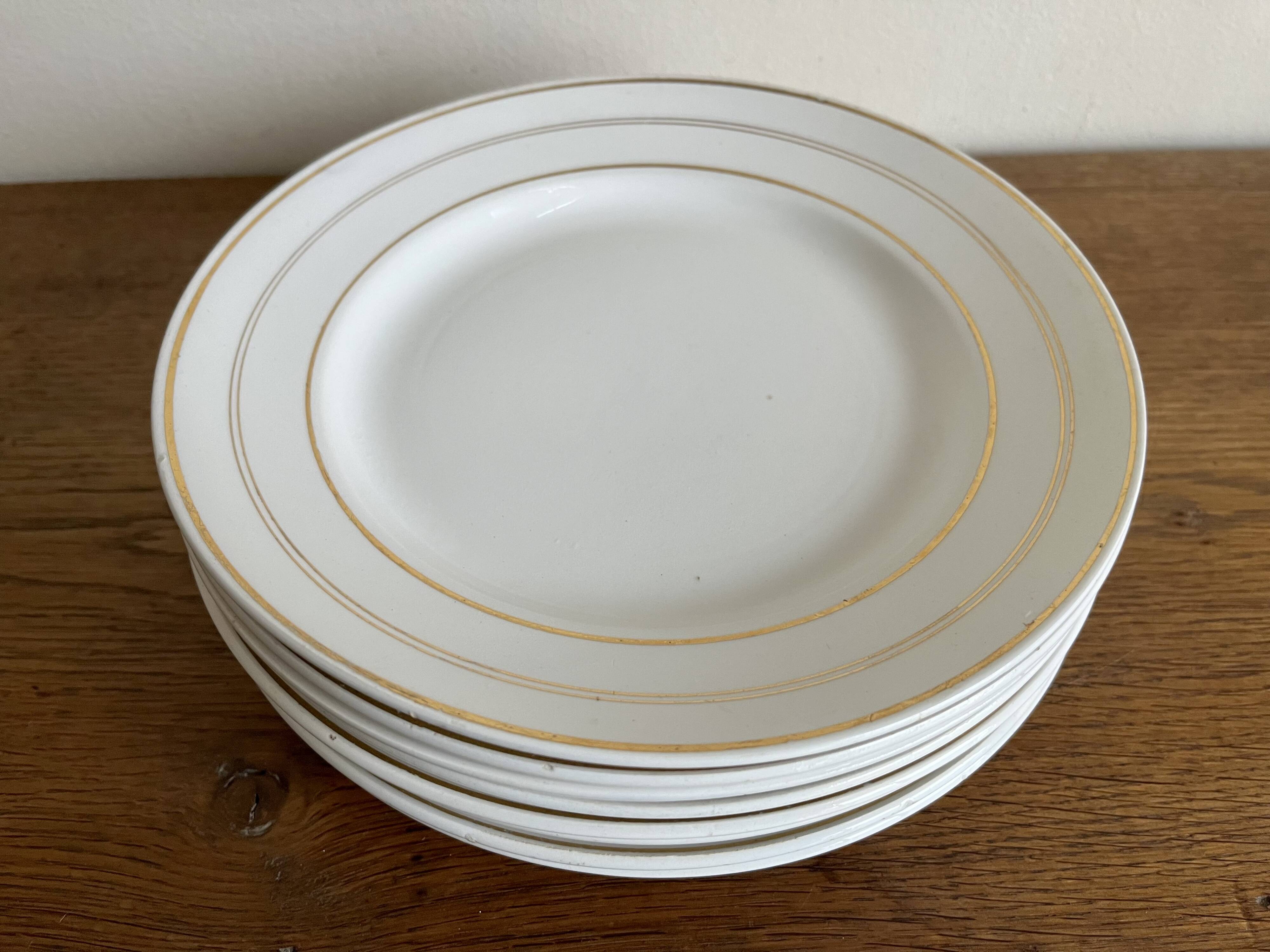 Set of 8 modernist flat plates in fine earthenware with pure gold trim, 1930.