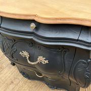 Commode galbée peinte en noir et bois