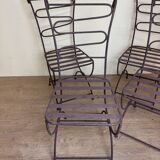 Series of four designer cast iron chairs with reversed backs and very beautiful x-legs