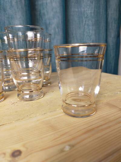 Set of 9 antique glasses with gold rim.