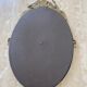 Oval mirror in gilded brass