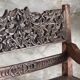Small antique Indonesian bench in carved teak with plant and floral motifs.