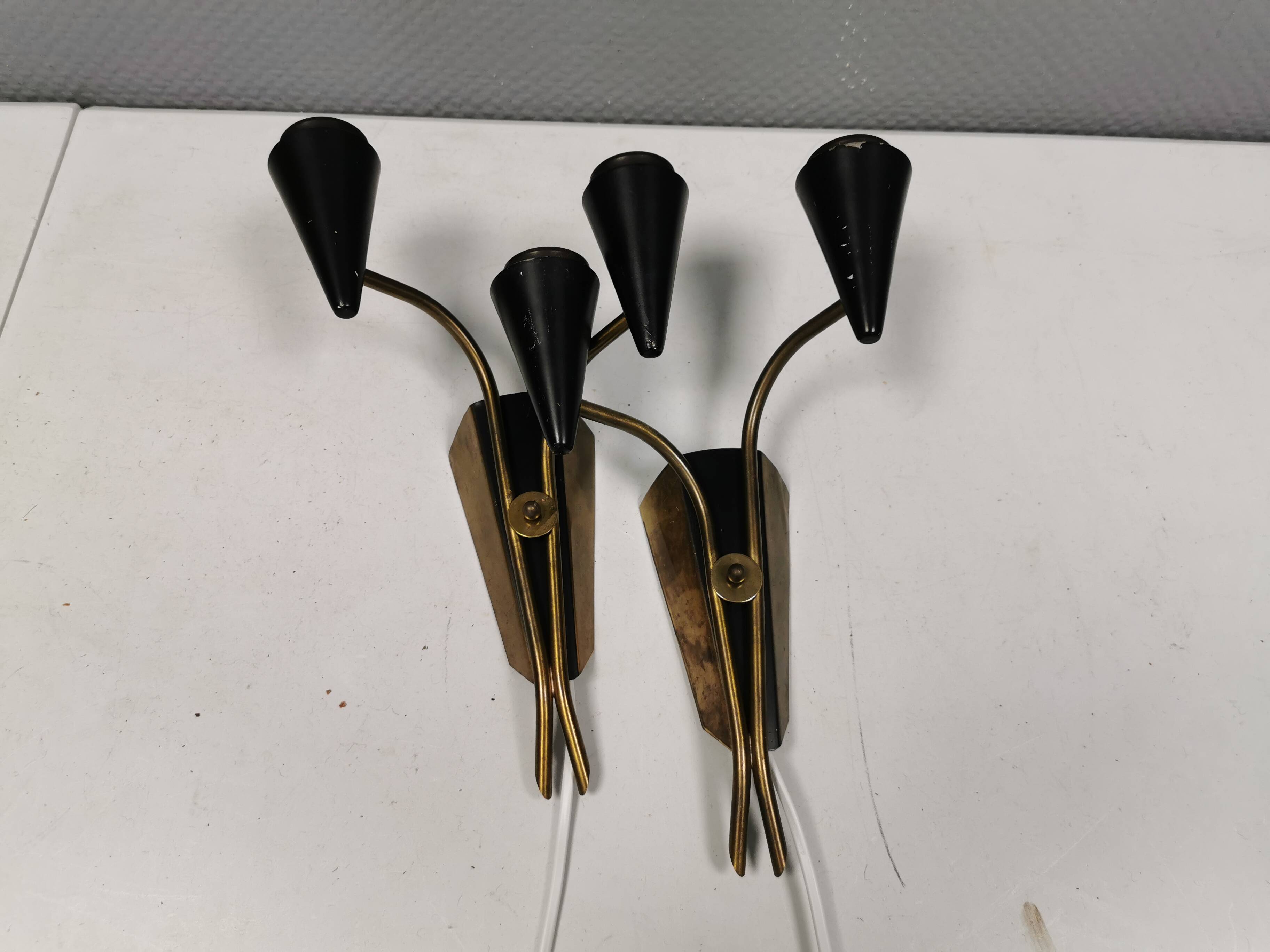 A set of wall lamps in black lacquered metal with brass details