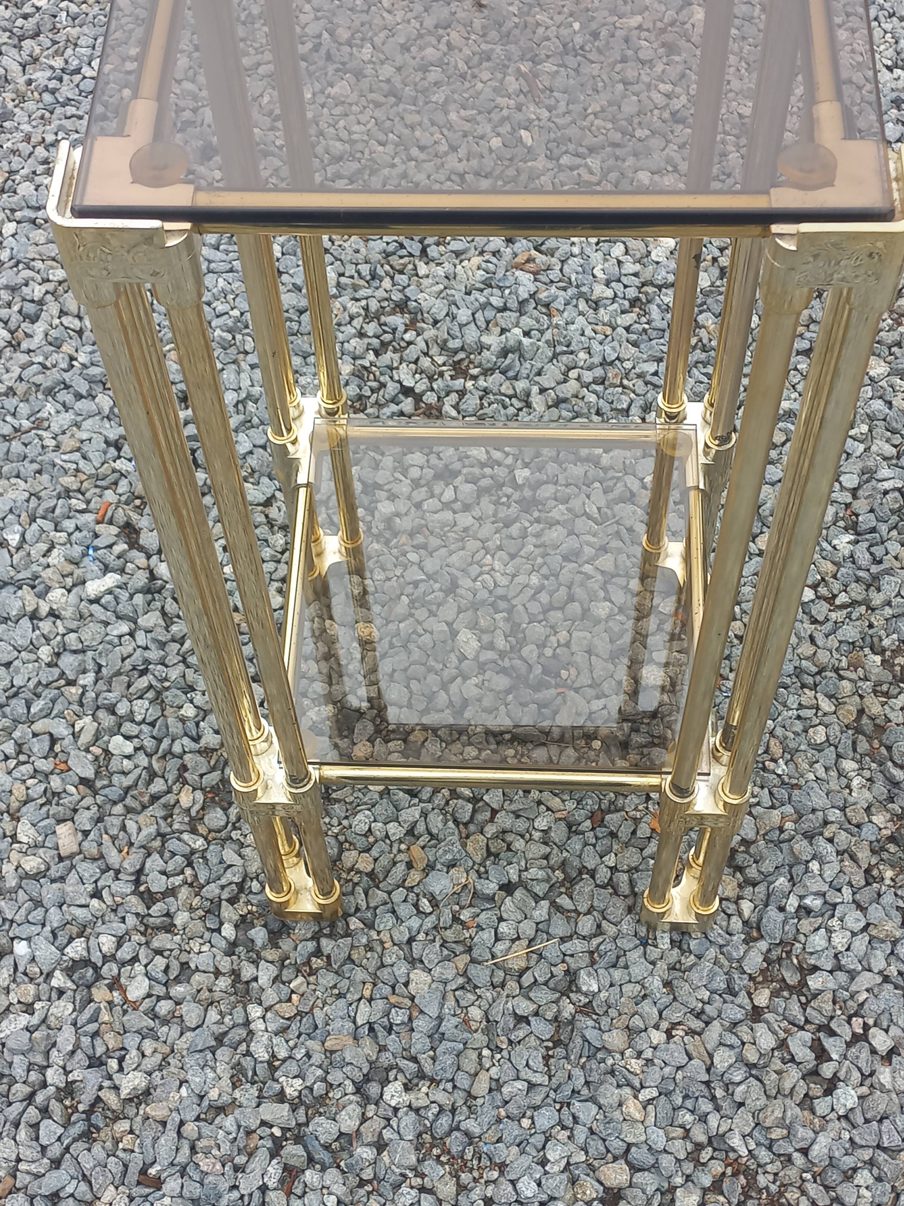 Pair of Hollywood Regency side tables in gold metal and smoked glass.