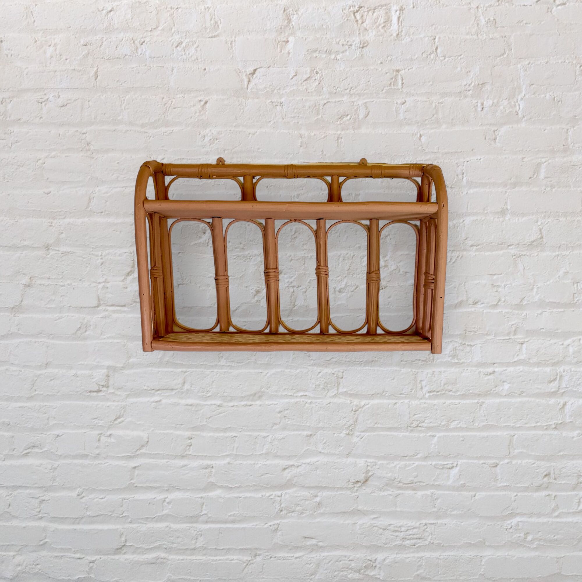 Pale pink rattan wall shelf