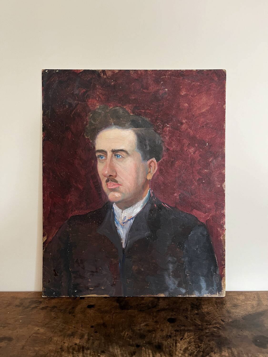 Old oil painting on cardboard portrait of a man in a dark suit