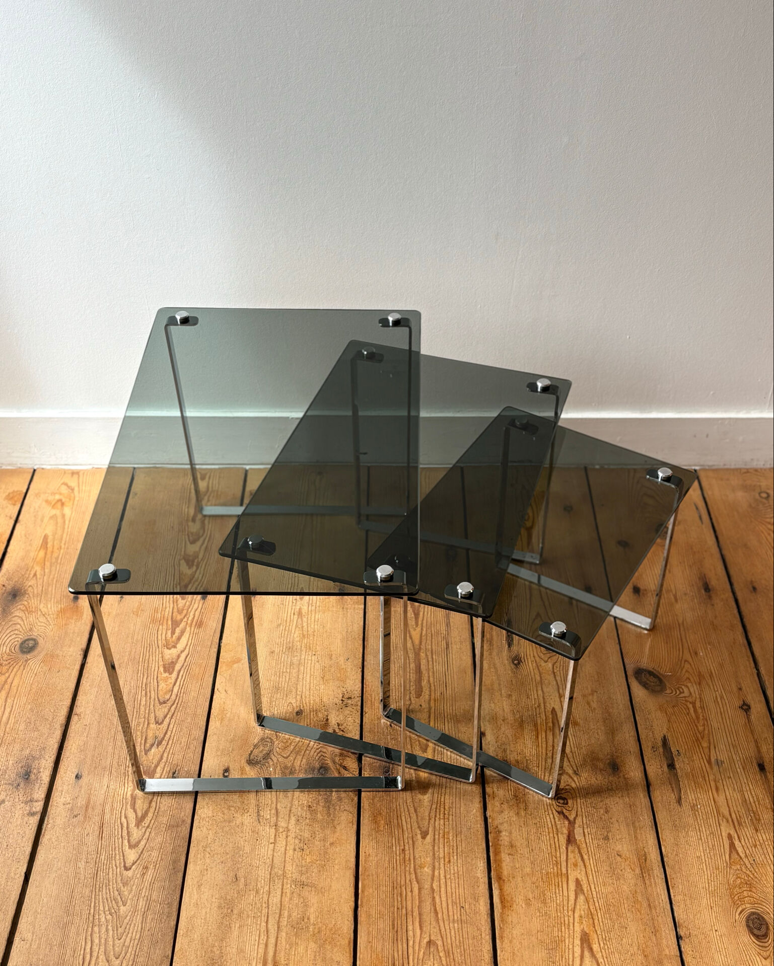 Nest of coffee tables in chrome with smoked glass top.