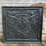 huge old fireplace plate has decoration of angels, crown and fleurs-de-lis