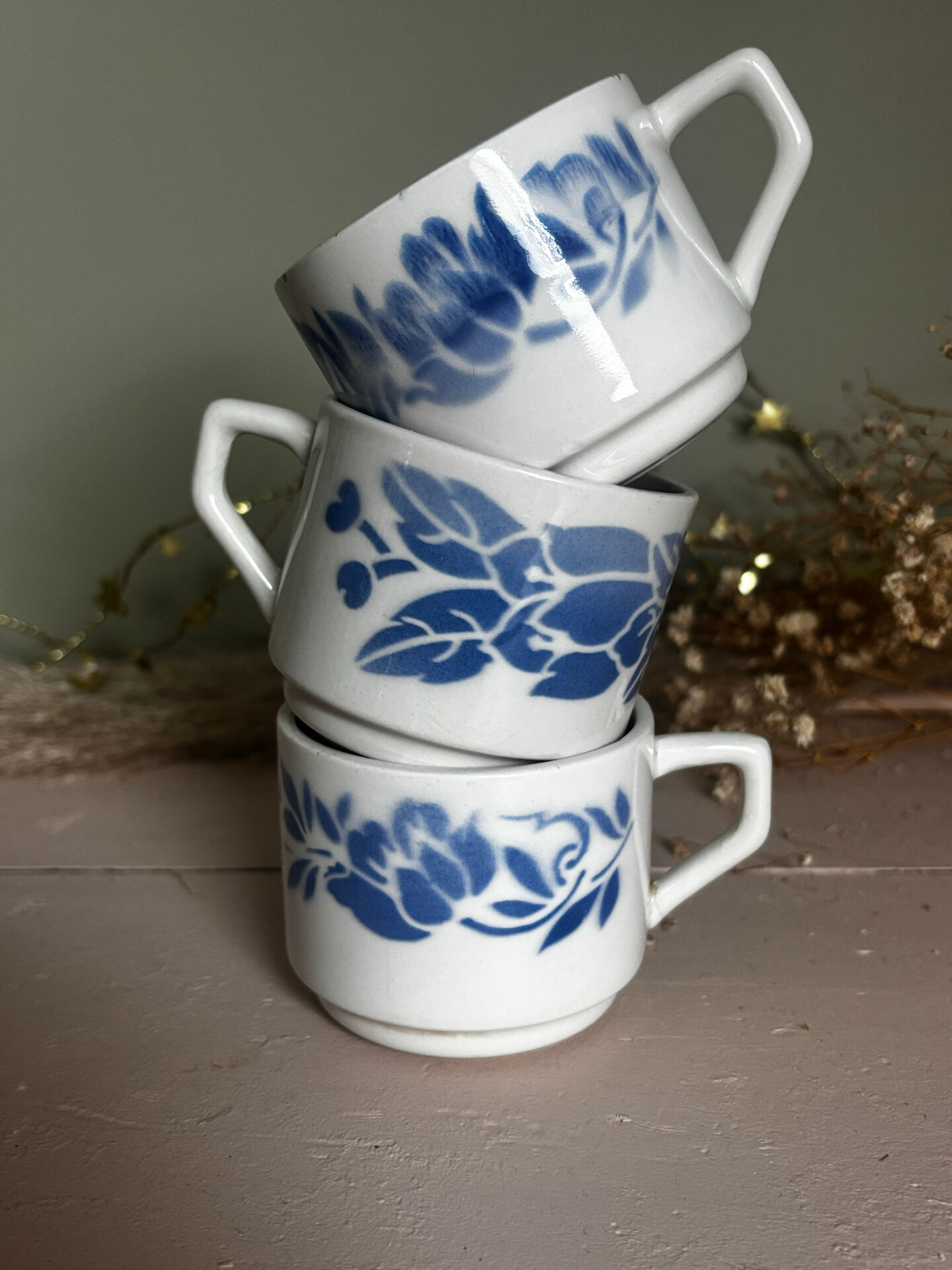Set of 3 antique ceramic cups with blue floral pattern.