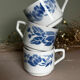 Set of 3 antique ceramic cups with blue floral pattern.