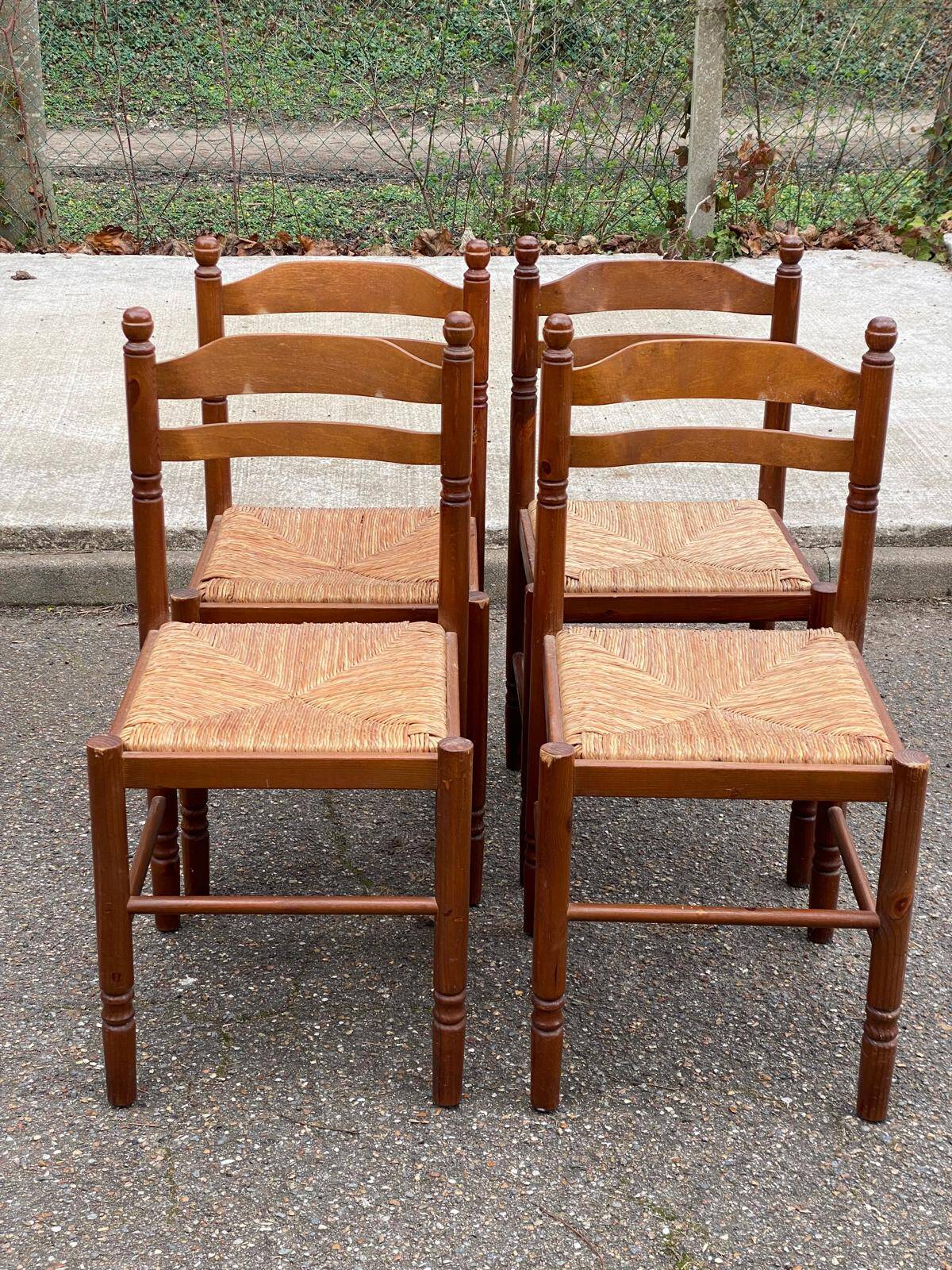 4 dining or kitchen chairs made of solid wood with rush seats.