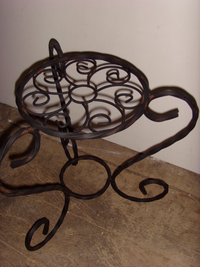 Sellette porte plante en fer forgé noir.