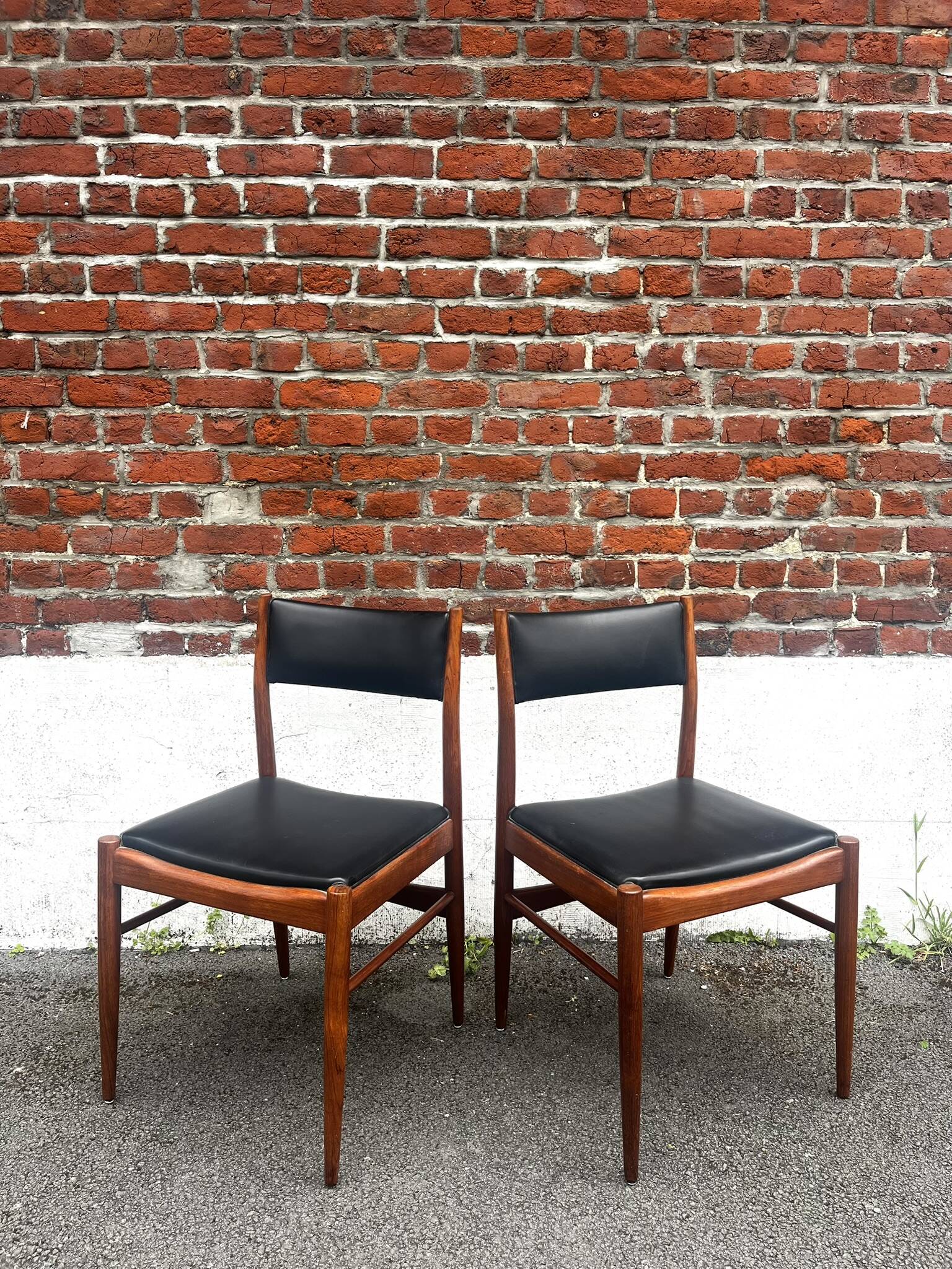 Set of 2 vintage Scandinavian chairs in wood and black faux leather.