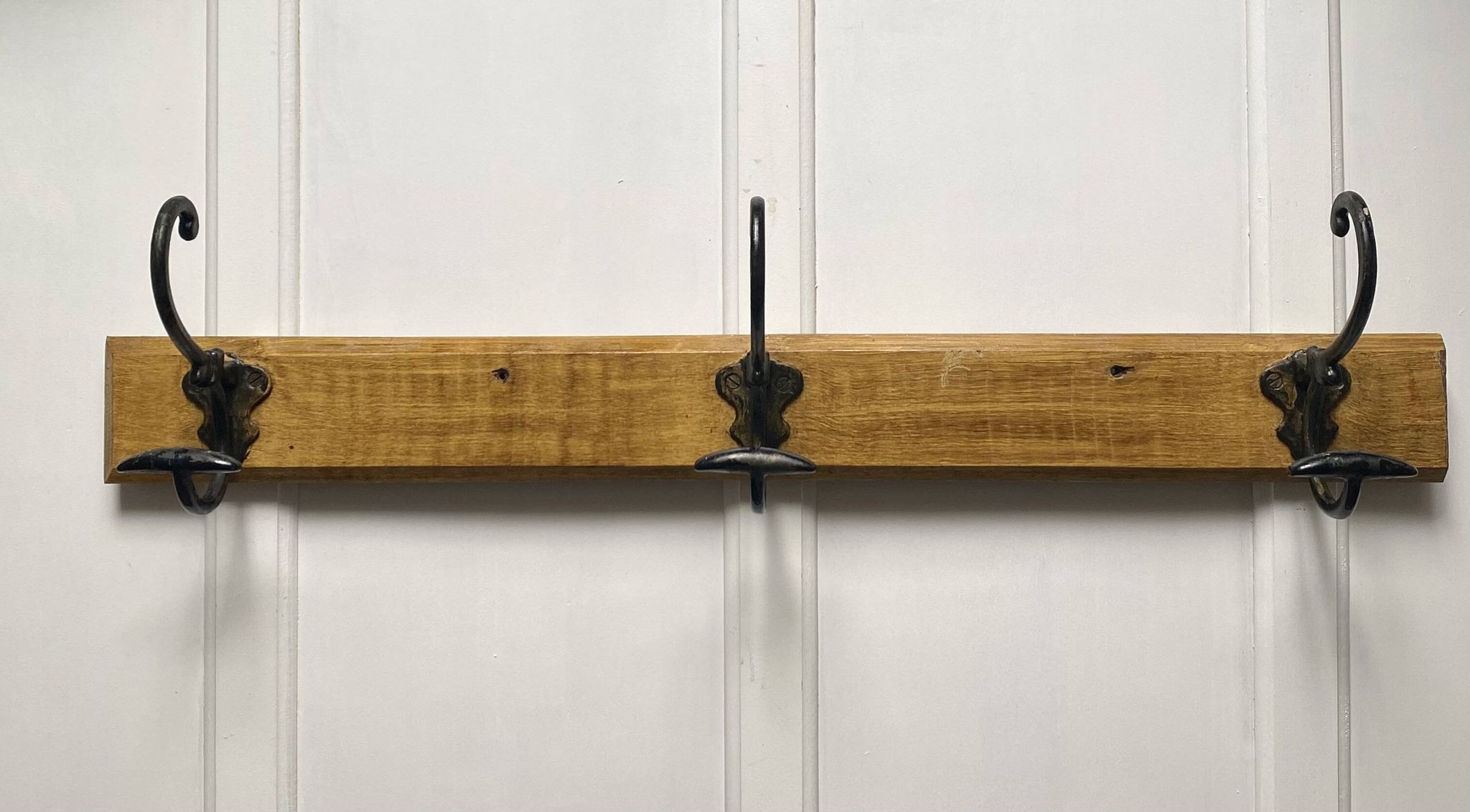 Antique wooden coat rack with metal hooks