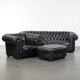 Ensemble composé d'un canapé chesterfield noir, d'un fauteuil et d'un pouf.