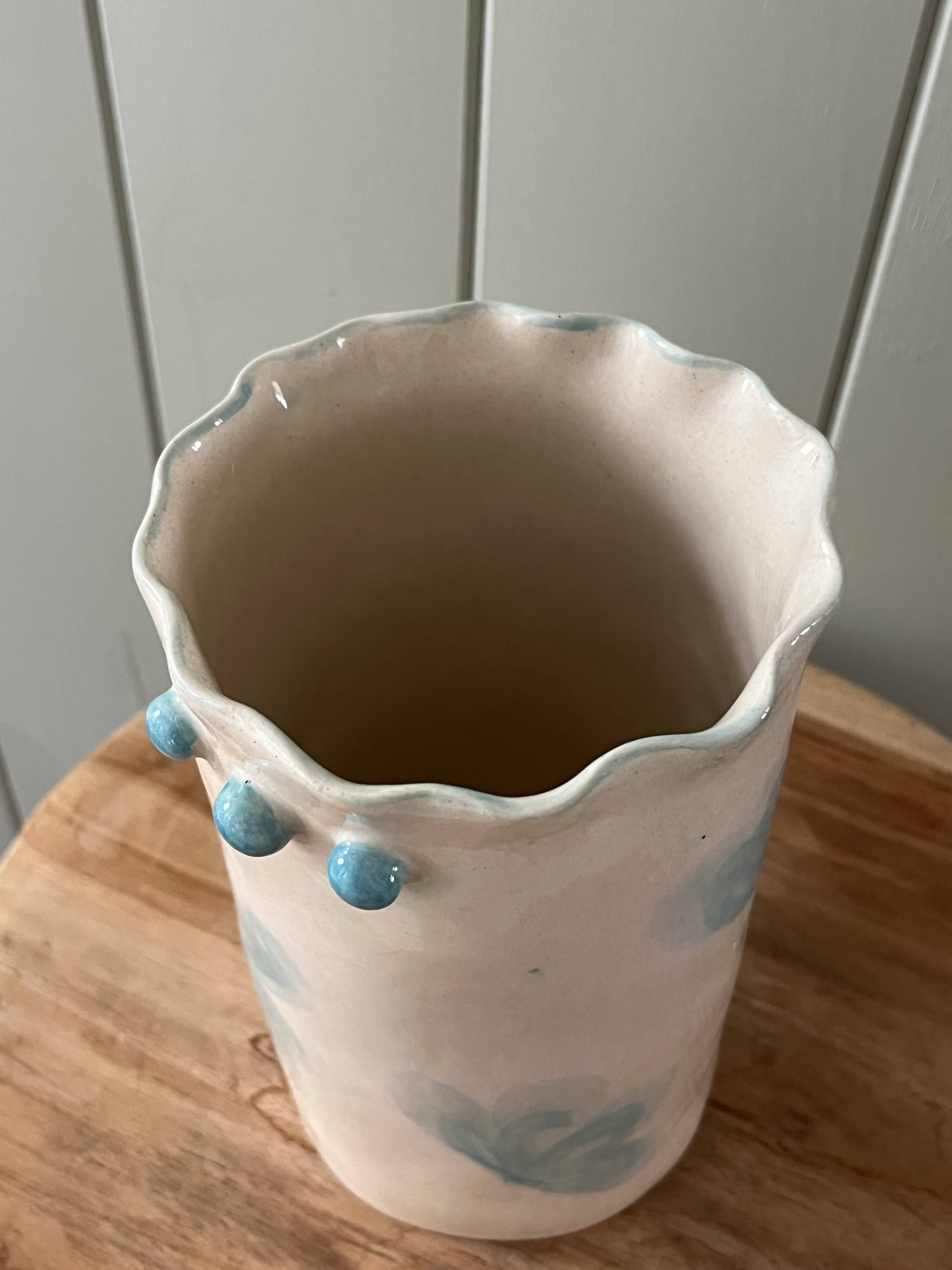 Stoneware vase decorated with flowers in a watercolour style.