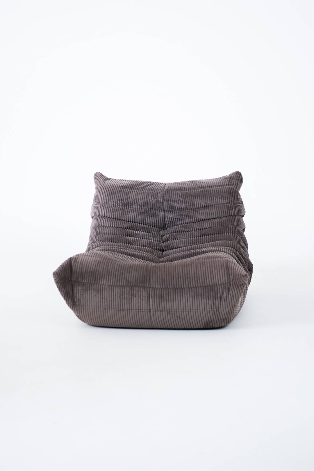 Ensemble de chaise et pouf Togo en velours côtelé marron.