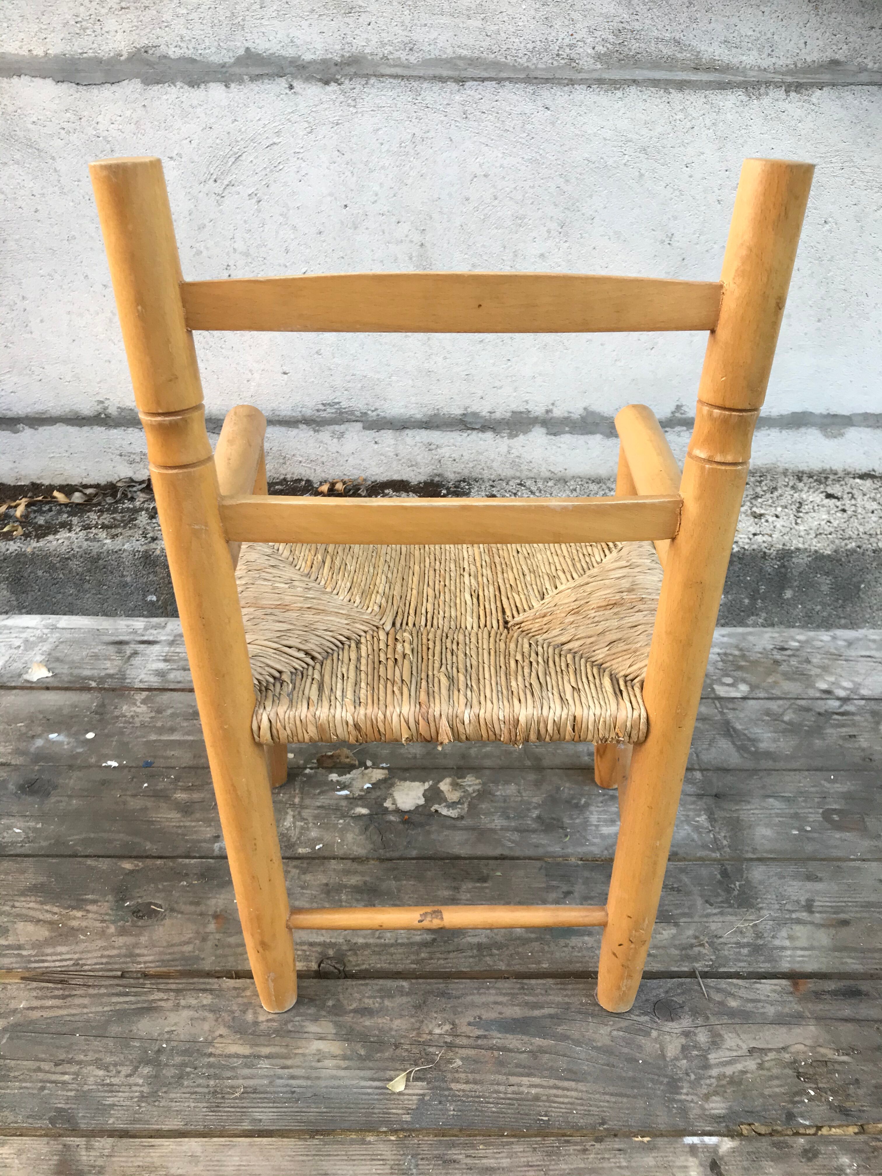 Old wooden children's armchair and vintage woven straw seat