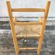 Old wooden children's armchair and vintage woven straw seat