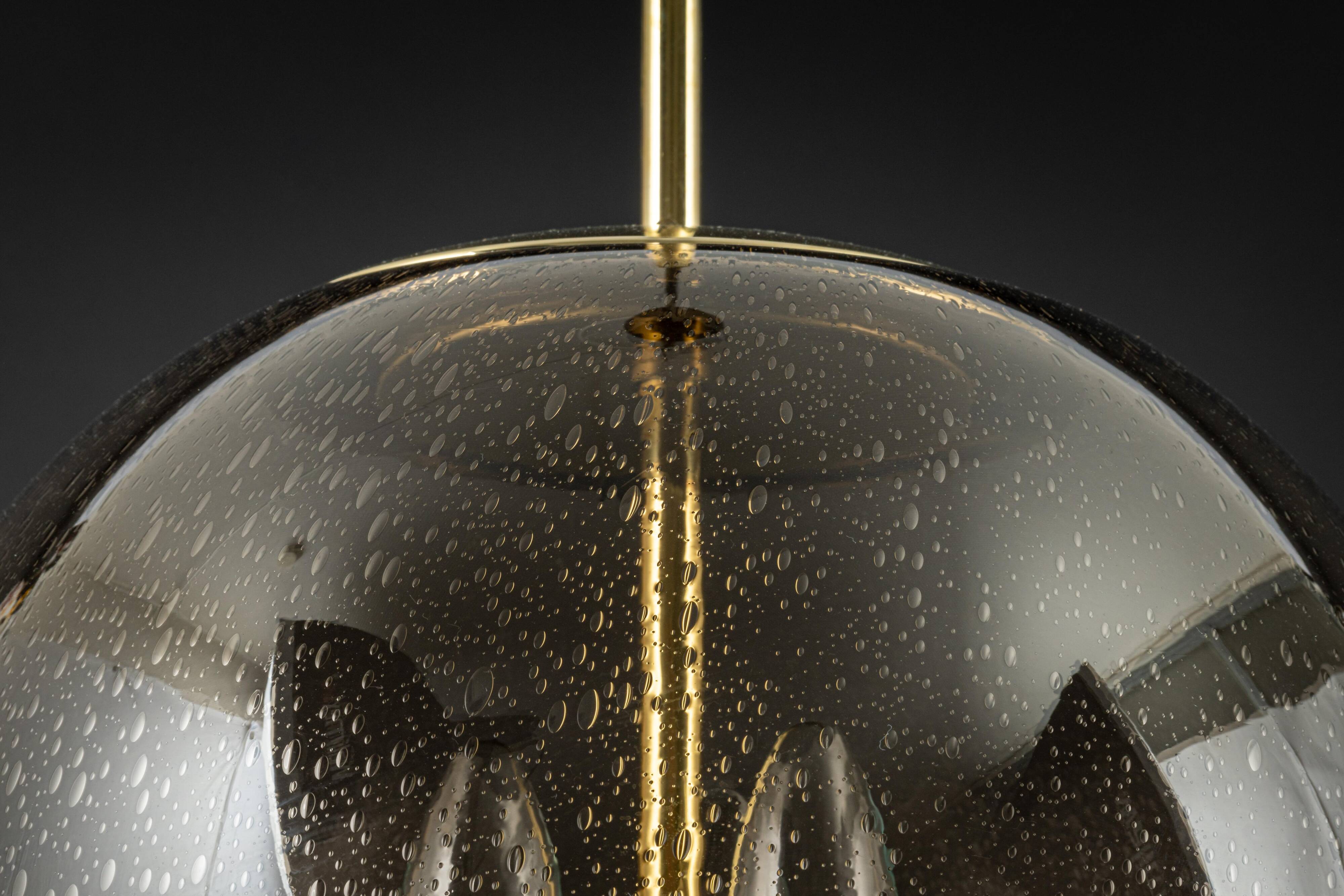 Large Limburg pendant light in brass with smoked glass ball, Germany, 1970s.