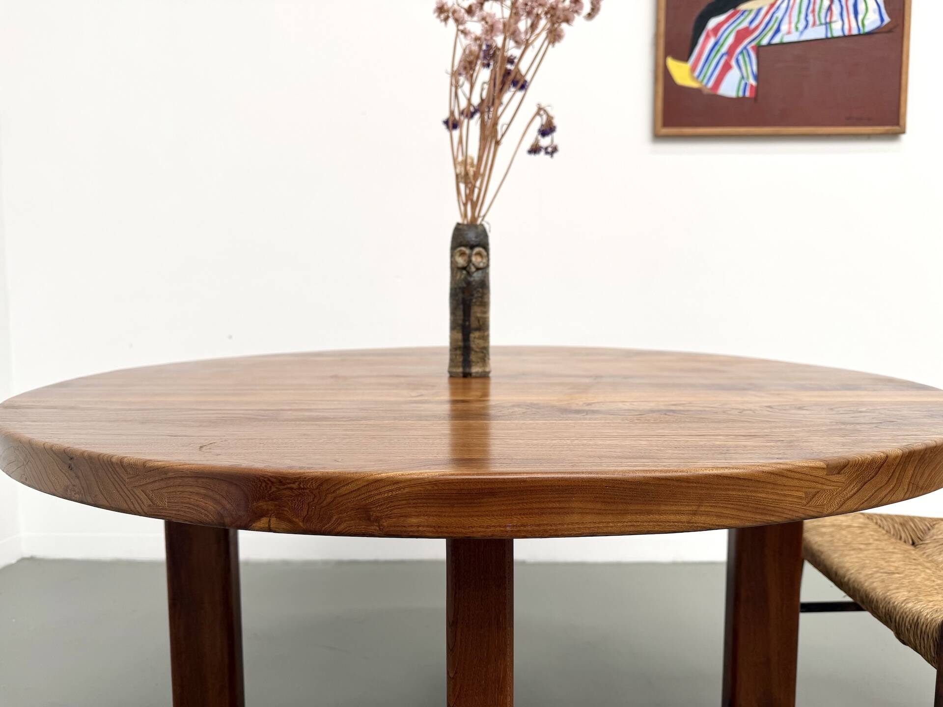 Modernist round table in solid elm, crossed legs.