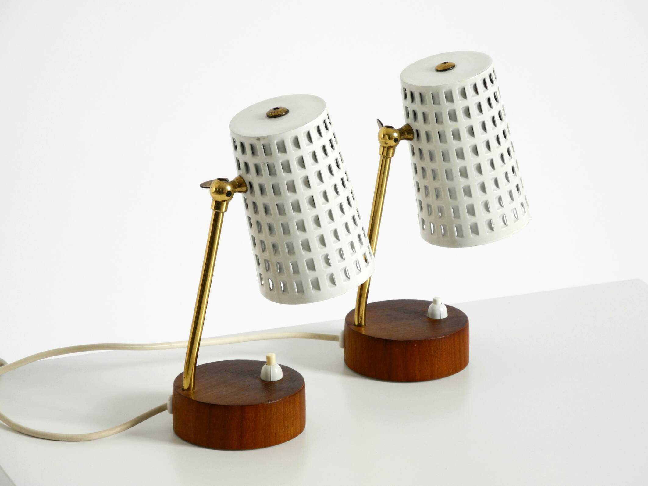 A pair of mid-century modern bedside lamps with perforated metal shades