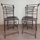 Series of four designer cast iron chairs with reversed backs and very beautiful x-legs