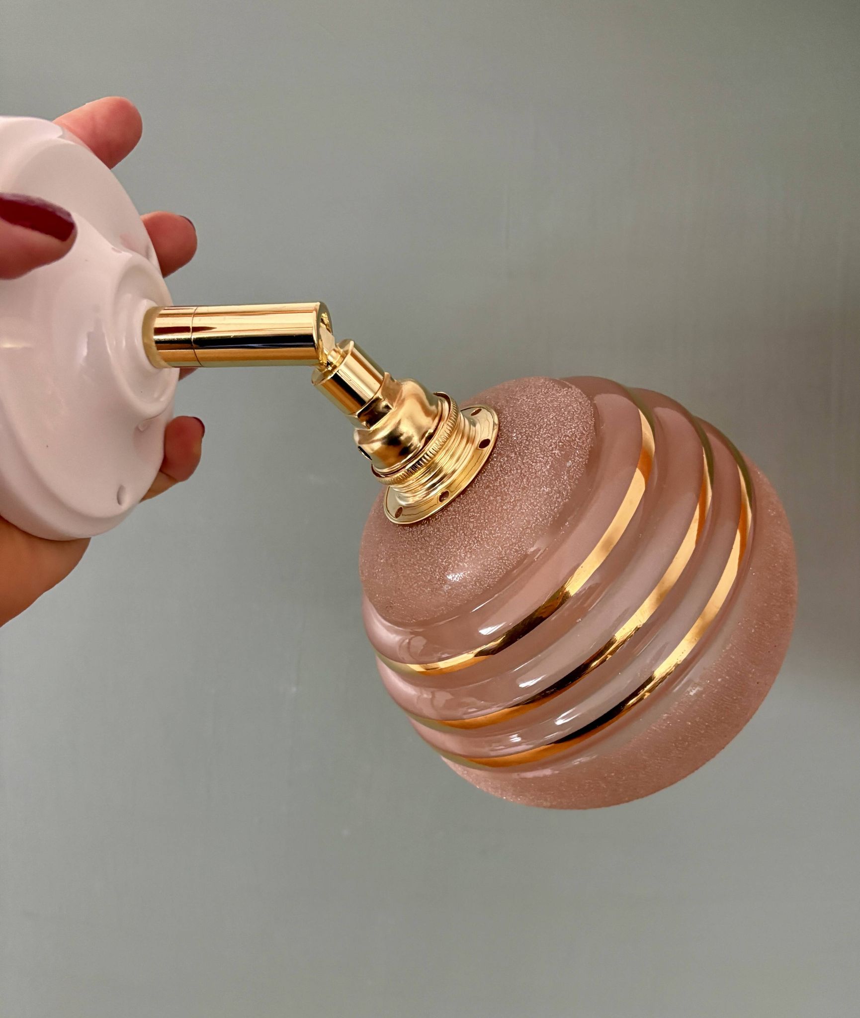 Vintage globe wall light in frosted pink and gold glass.