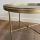 Round coffee table in brass with a black lacquered glass top from Maison Jansen.