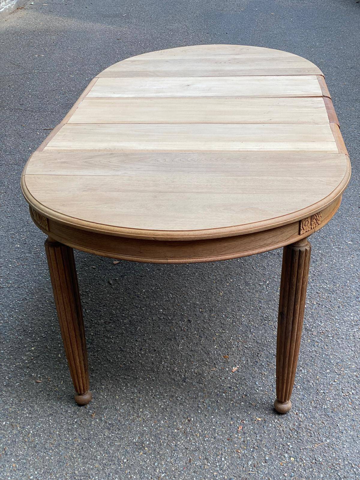 Large stripped solid oak dining table in Louis XVI style with 3 extensions.