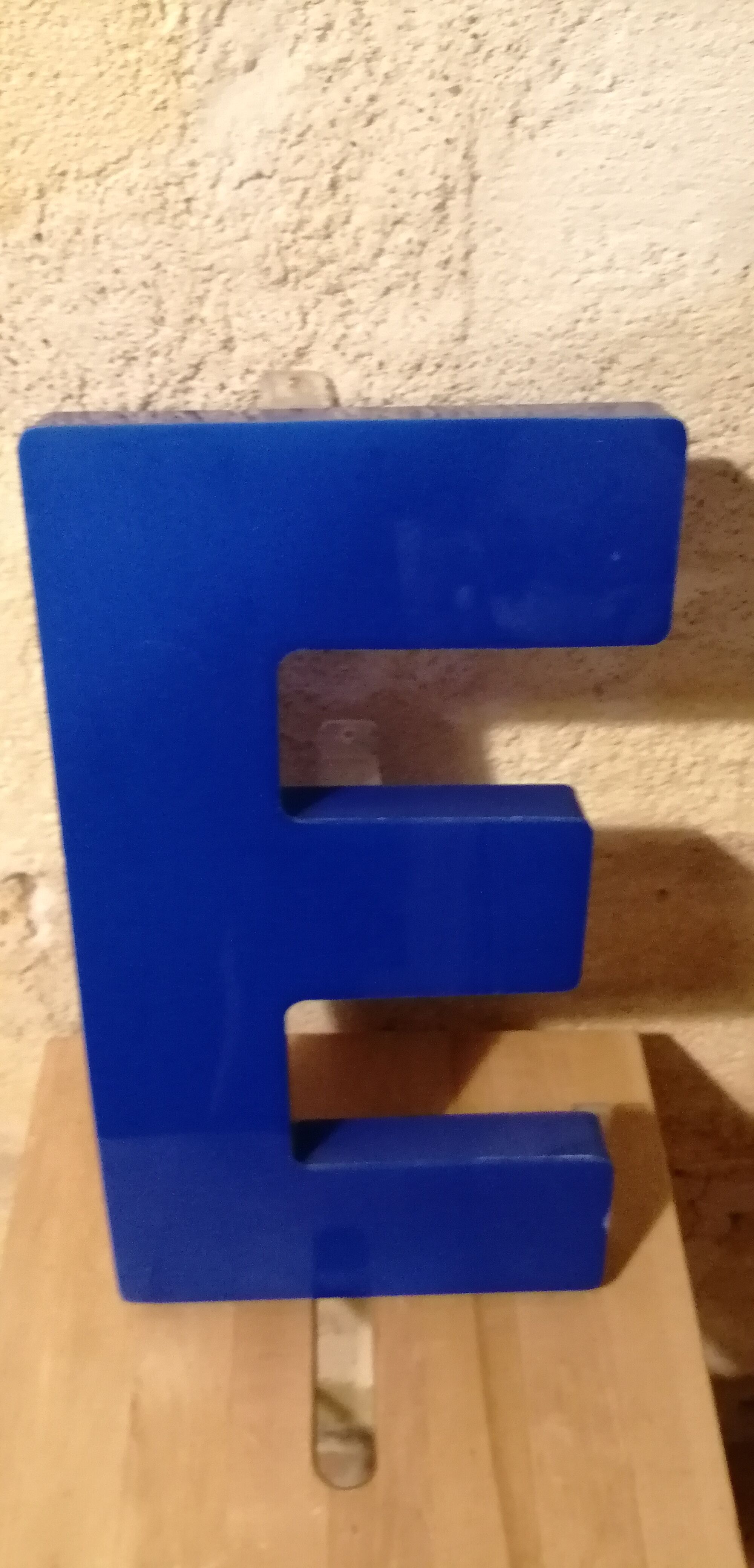 Letter E vintage sign in blue plexiglass