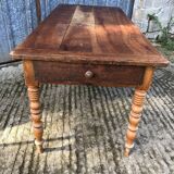 Antique farmhouse table in solid cherry wood with turned legs.