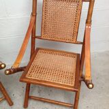 Pair of folding chairs in bamboo and caning, leather and brass
