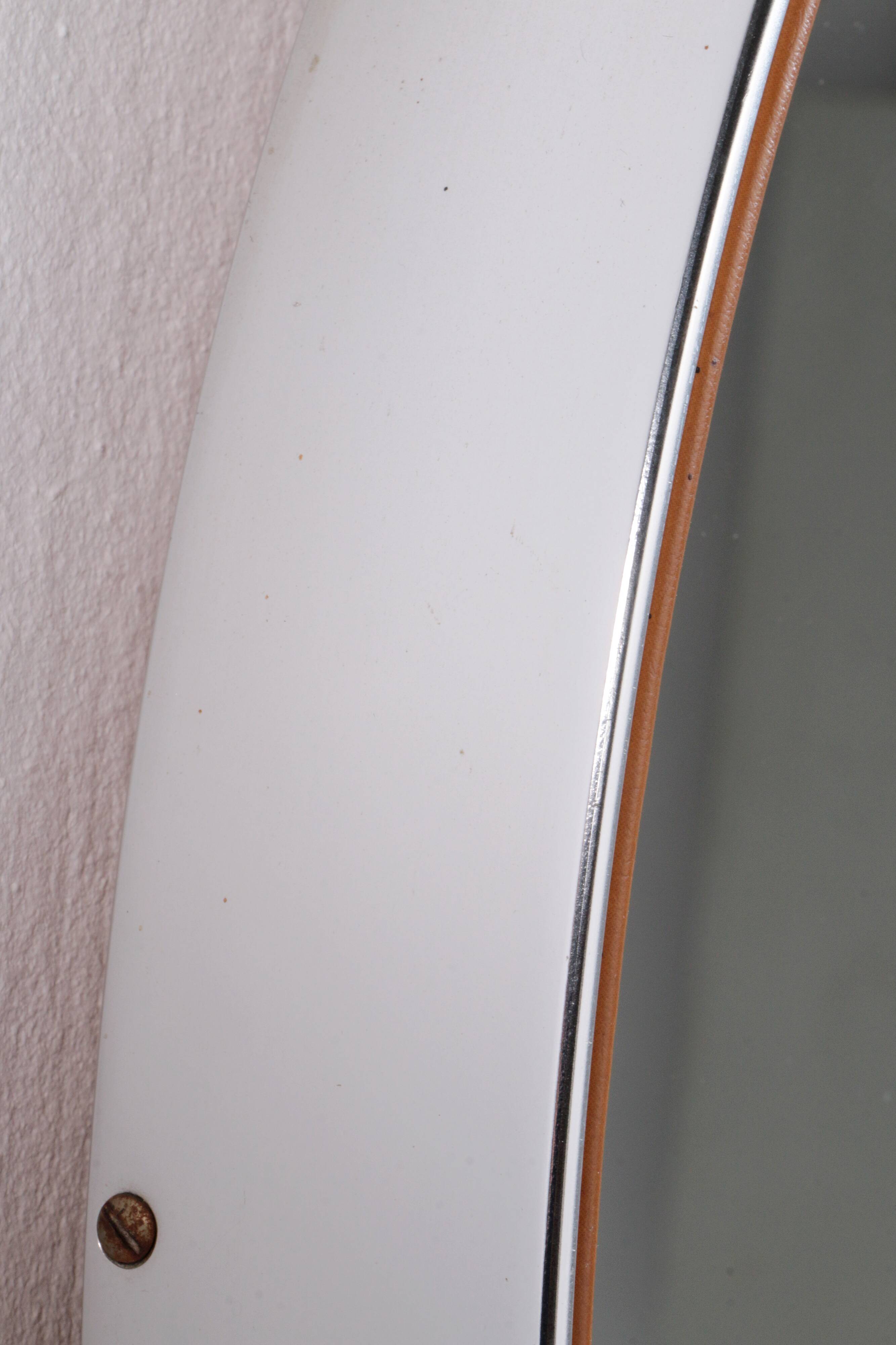 Round mirror covered with leather and chrome, made in France in the 1970s.