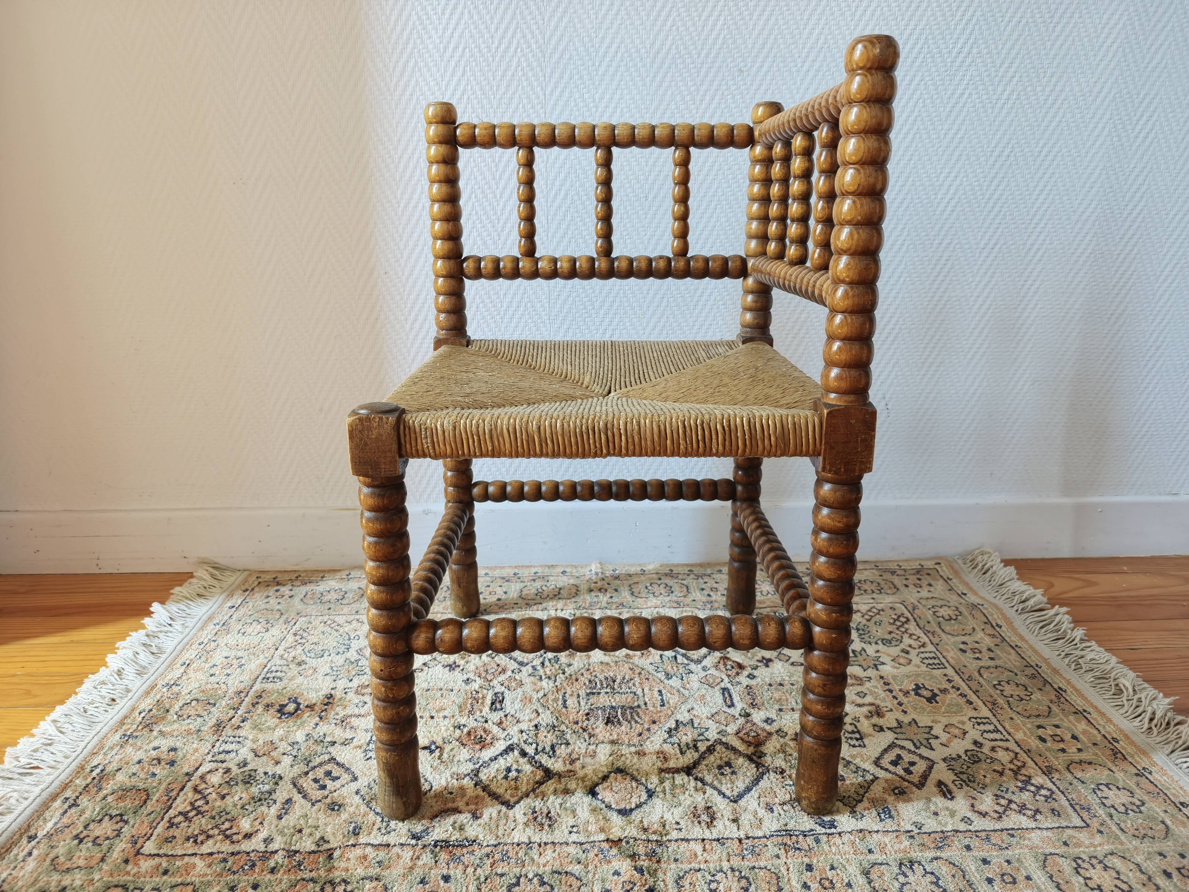 Antique corner chair by the fire with turned wood and straw seat.