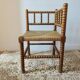 Antique corner chair by the fire with turned wood and straw seat.