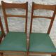6 modern chairs with banded backs and green faux leather seats.