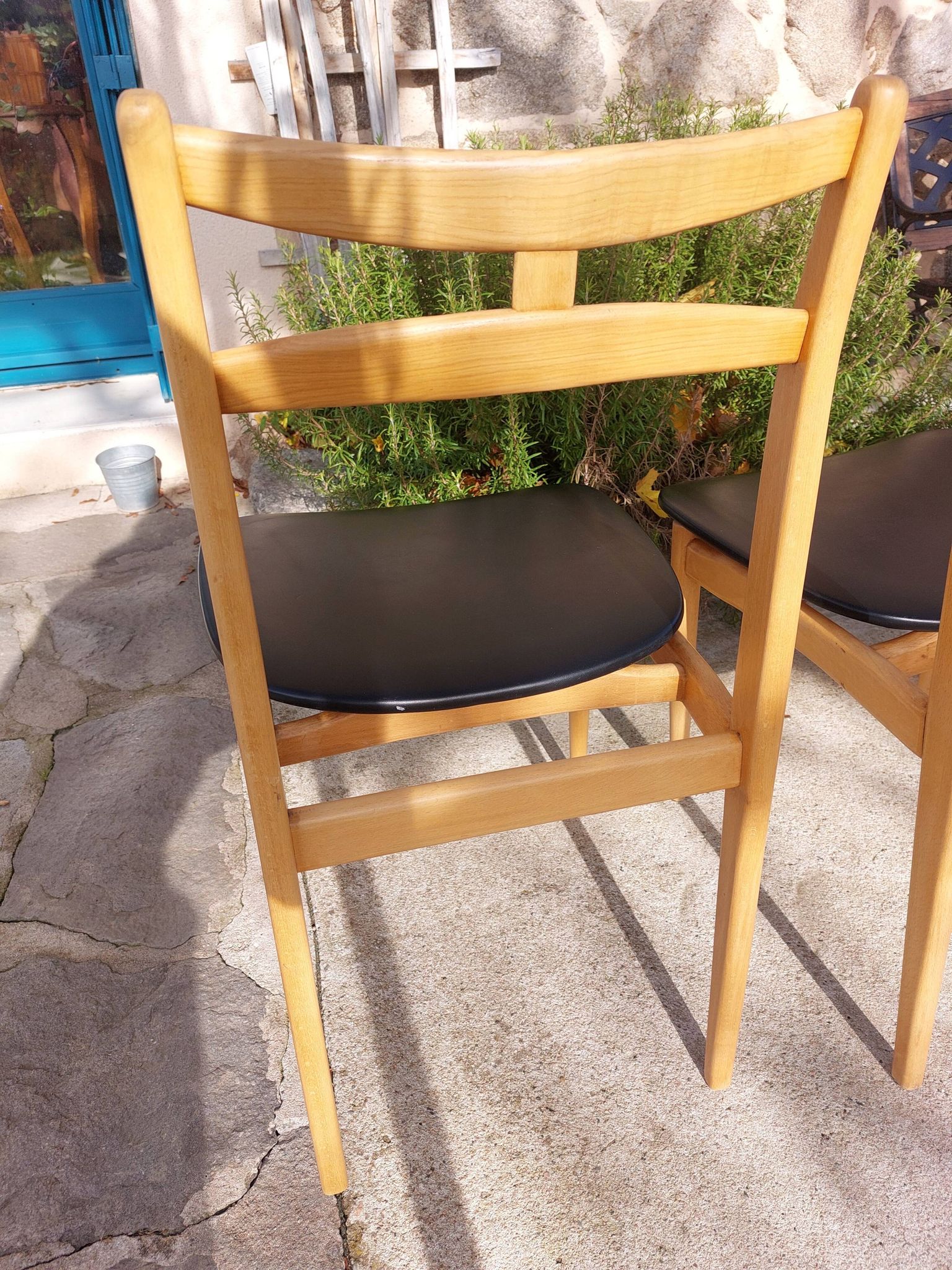 3 Scandinavian style chairs, light wood and black faux leather.