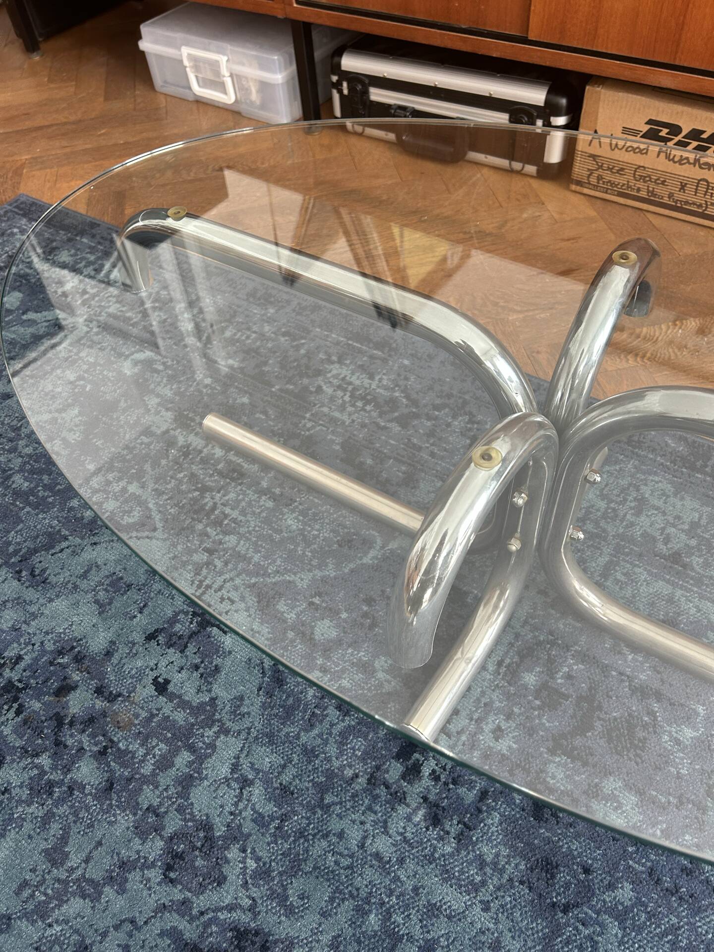 Oval glass coffee table with chrome legs, vintage 70s design.
